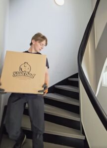 Person bærer Studbud-eske ned trapp